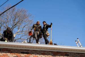two men posing on top of a roof